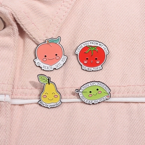 Detail of four cute fruit enamel pins with pun phrases on pink denim fabric background
