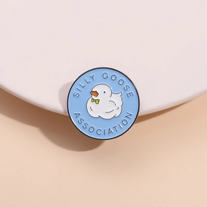 Silly Goose Association blue round enamel pin with white cartoon goose and green bowtie