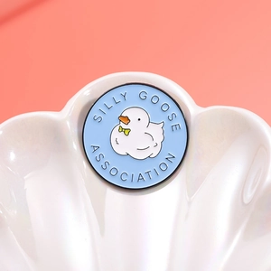 Blue Silly Goose Association enamel badge with cartoon duck and yellow bow accessory