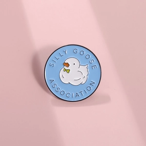 Cartoon blue goose metal badge with SILLY GOOSE ASSOCIATION engraving on pink background