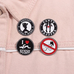Detail of four enamel pins with humorous slogans on pink denim fabric material