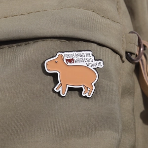 Capybara enamel pin on olive green canvas bag with funny English text detail