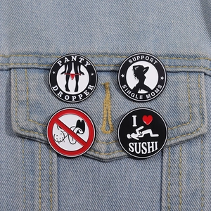 Detail of four fun enamel pins with adult humor on a blue denim jacket pocket