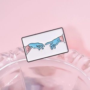 Cartoon enamel brooch featuring blue medical gloves in a creative artistic Adam gesture