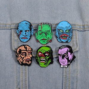 Detail view of colorful classic movie monster enamel pins on blue denim jacket