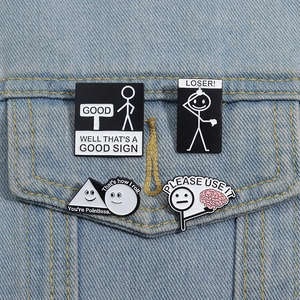 Detailansicht von vier lustigen Emaille-Pins auf der Tasche einer Jeansjacke