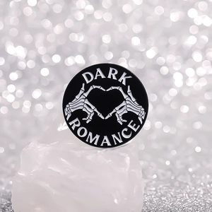 Spilla rotonda gotica in smalto con mani a teschio a cuore e scritta Dark Romance