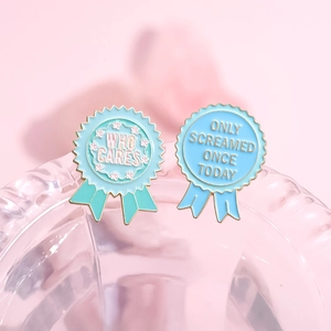 Enamel medal brooches with WHO CARES and ONLY SCREAMED ONCE TODAY text slogans