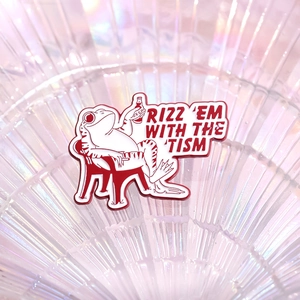 Cartoon frog drinking beer enamel pin with Rizz Em With The Tism slogan on pink background