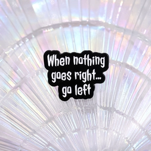 Black enamel pin with When nothing goes right... go left quote on iridescent background