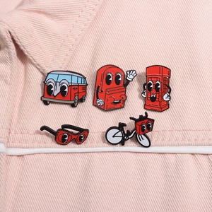 Detail of five red cartoon enamel pins including bus and telephone booth on pink denim