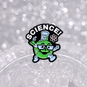 Cartoon science badge with green character holding flask and Science text on metal