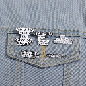 Close-up of five minimalist math-themed enamel pins displayed on a blue denim jacket pocket