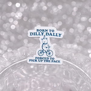 Spilla smaltata orso in bicicletta con scritta Born to Dilly Dally su vetro