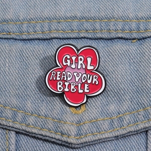 Detail of red flower enamel pin with Girl Read Your Bible text on denim jacket