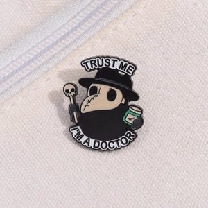 Close-up of a plague doctor enamel pin with 'Trust Me I'm a Doctor' text on canvas bag