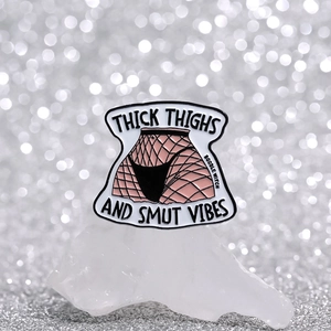 Thick Thighs And Smut Vibes enamel pin with fishnet stockings design on crystal stand