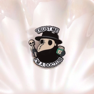 Plague Doctor enamel pin with Trust Me I'm a Doctor text on iridescent shell background