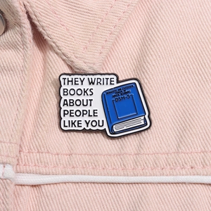 Detalle del pin esmaltado de libro DSM-5 con texto sarcástico en una chaqueta vaquera