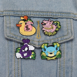 Detailed view of four cartoon animal enamel pins with money themes on a denim jacket