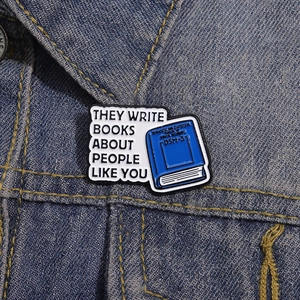 Detailed view of DSM-5 blue book enamel pin pinned on blue denim jacket fabric