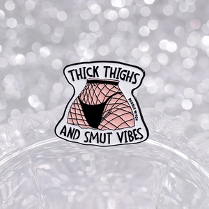 Unique enamel pin with thick thighs motif and smut vibes lettering on glass edge