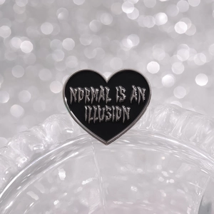 Black heart enamel brooch pin with Normal Is An Illusion text and silver metal frame