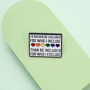 Rainbow heart enamel pin with inspirational quote on a minimalist display stand