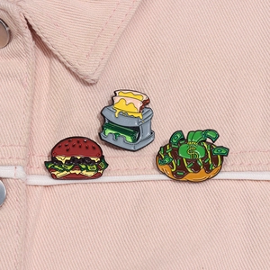 Detailed close-up of cartoon enamel pins featuring dollar burger and donut on a denim jacket