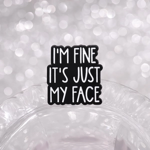 Black enamel brooch with I'M FINE IT'S JUST MY FACE quote on glass rim