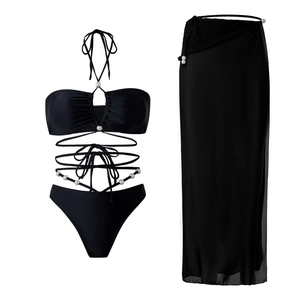 Detailed view of black three-piece bikini set with pearl accents and matching chiffon cover-up