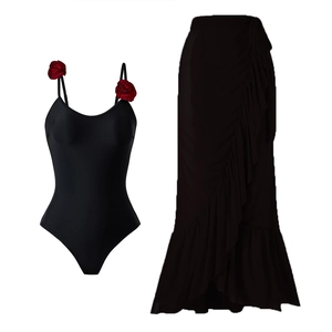 Detail of black one-piece top with 3D red roses and a layered ruffled maxi skirt