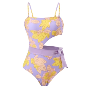 Detail of floral gradient one-piece swimsuit featuring side cutout and waist tie accents
