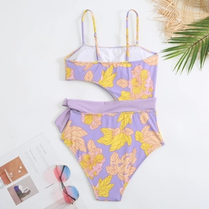 Flat lay of purple floral one-piece swimsuit with cut-out waist and tropical leaf print