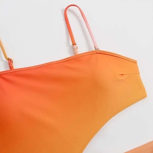 Detailed view of adjustable straps and orange yellow gradient fabric on swimsuit