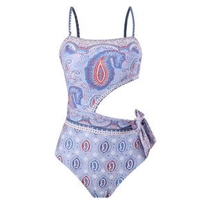 Detail of paisley print one-piece swimsuit featuring side cut-outs and bow tie knot