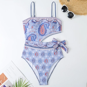 Detailed flat lay of blue paisley one-piece swimsuit with cut-out waist and bow tie detail