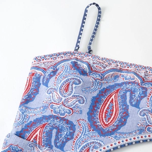 Detailed macro view of retro paisley print fabric and polka dot strap with metal buckles