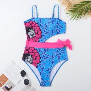 Detail of blue one-piece swimsuit with pink floral print and side cutout bow accent