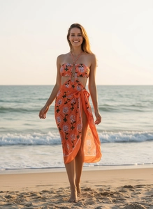 Close-up of orange floral one-piece swimsuit with cutout detail and beach sarong