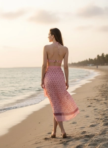Detail of pink floral beach cover-up and matching bikini with ethnic lace trim at sunset