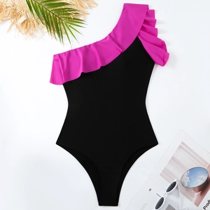 Flat lay of a one-piece ruffle swimsuit with sunglasses and summer holiday accessories