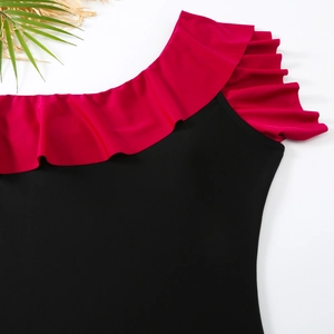 Detail of swimsuit ruffles with elegant black and rose red color contrast and palm leaf