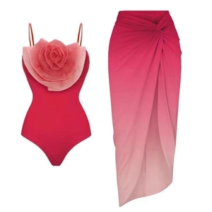 Detail of swimsuit bodysuit with large 3D floral applique and gradient wrap skirt