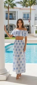 Detailed view of blue and white floral bikini top with ruffles in a luxury poolside setting