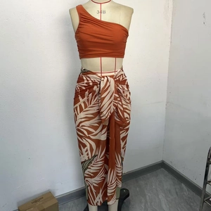 Two-piece bikini set with one-shoulder ruched top and tropical palm leaf wrap skirt