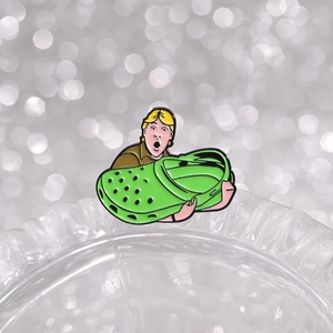 Kreative Emaille-Brosche mit Cartoon-Jungen, der eine große grüne Sandale hält