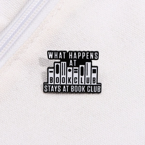 Gros plan d'un pin's de club de lecture noir et blanc sur fond de tissu en toile