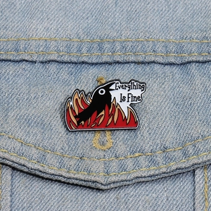 Detail of raven meme lapel pin on blue denim jacket with Everything Is Fine text