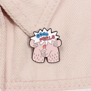 Detail van een creatieve roze emaille pin met Good Feels tekst op roze denim stof